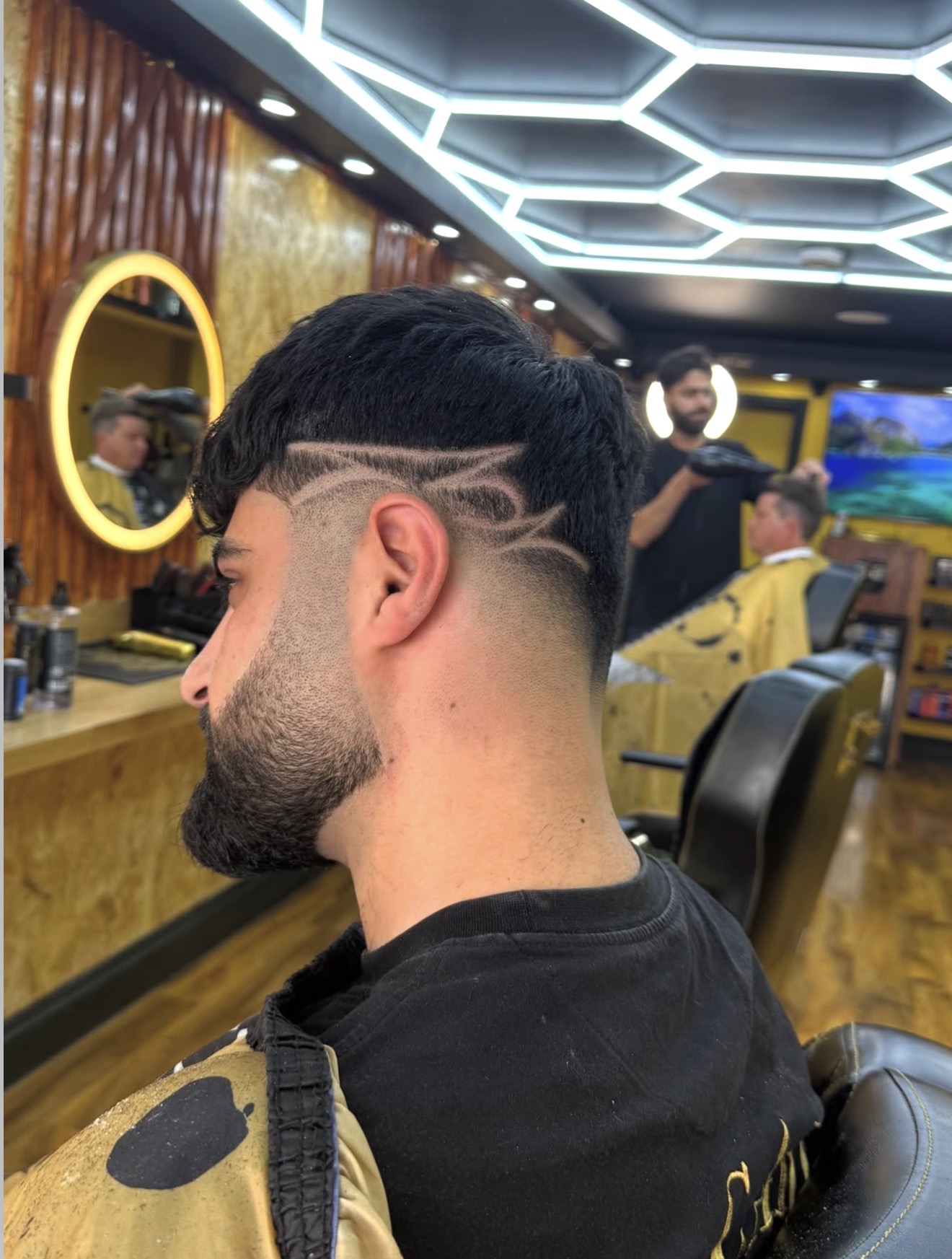 Textured crop with a sharp side hair design and full beard